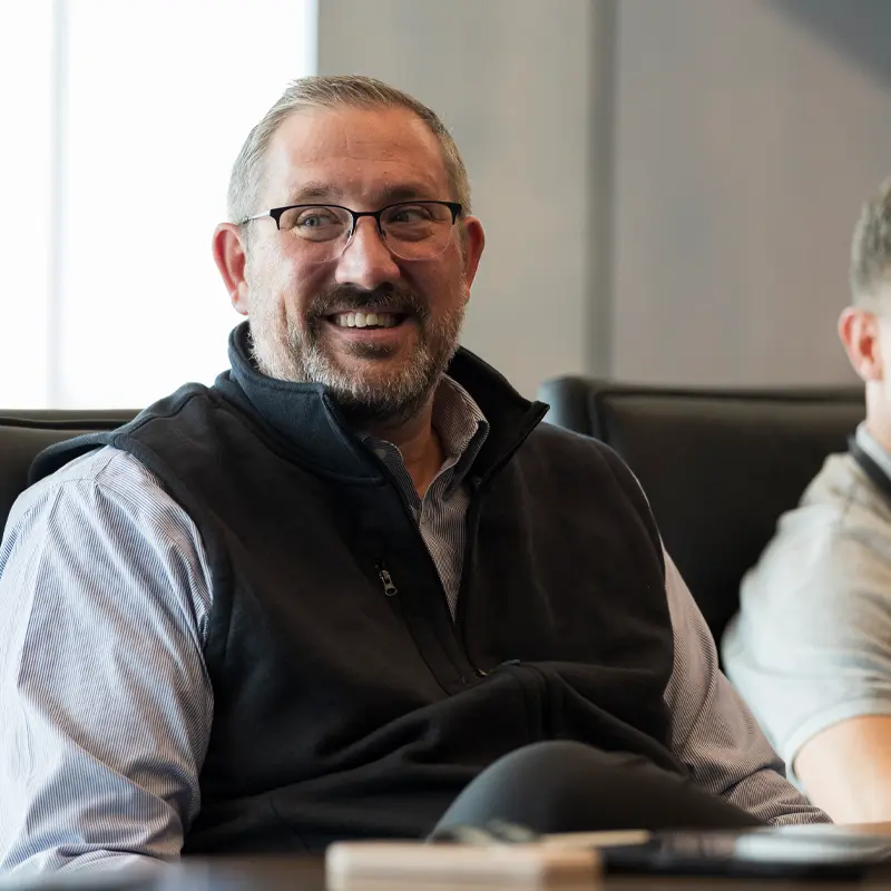 Man at conference table talking to others